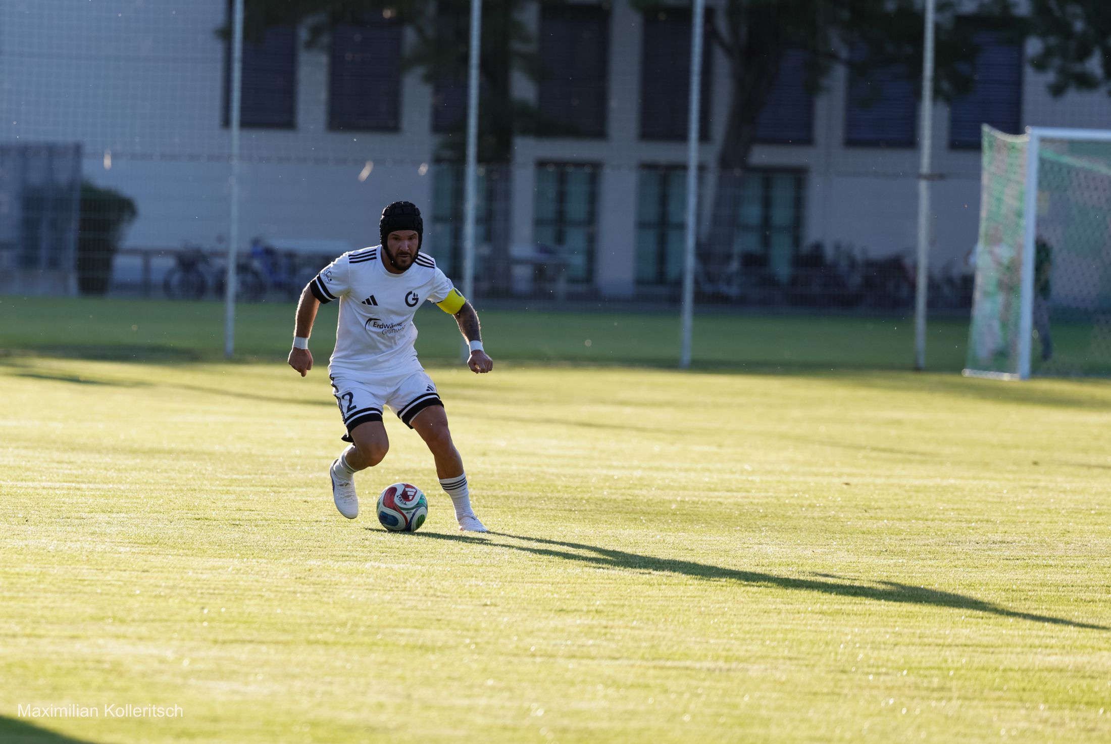 Spieler dribbelt über das sonnige Spielfeld