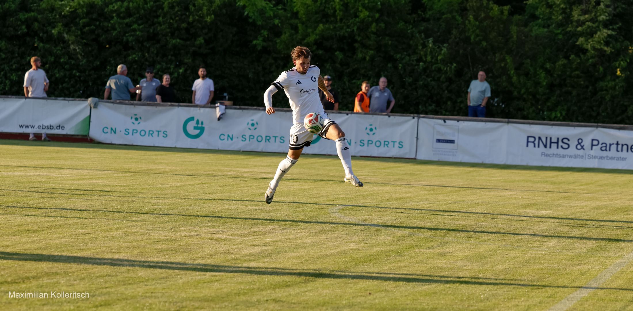Spieler springt zum Ball vor der Werbebande